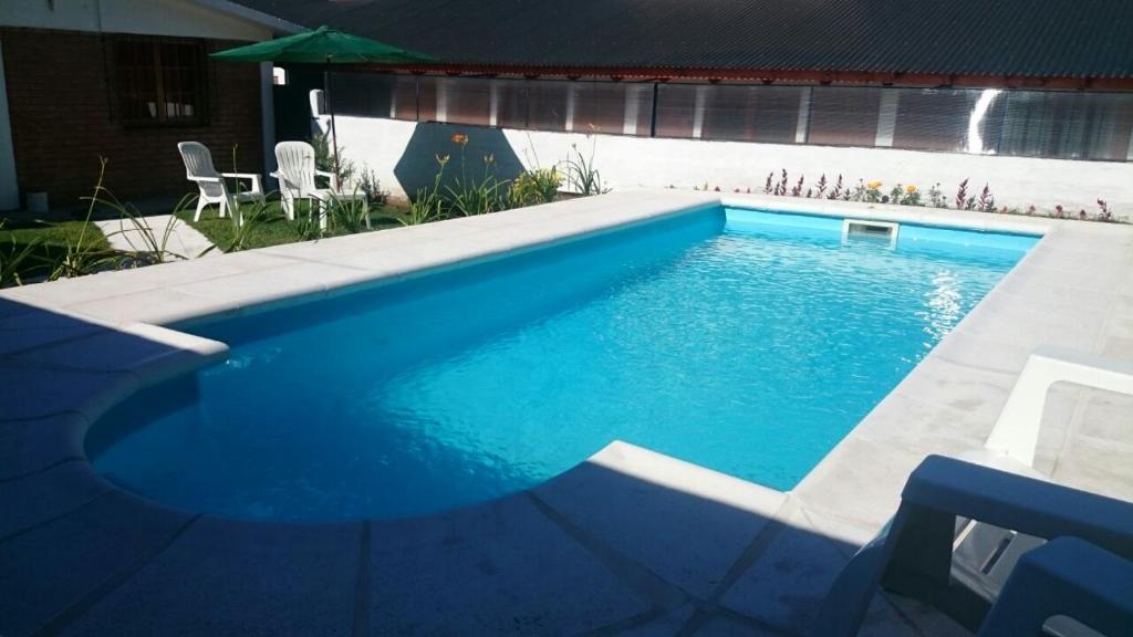 a swimming pool with blue water in a yard at Cabañas Simpson in Santa Rosa de Calamuchita