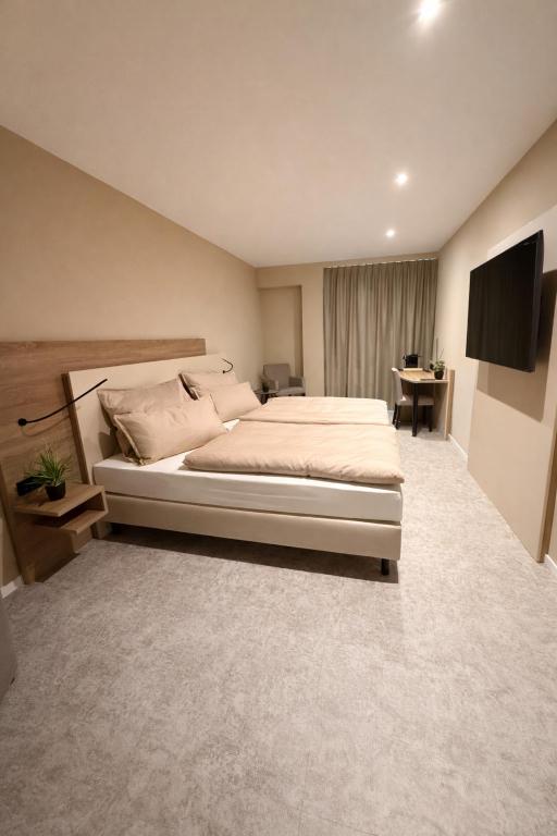 a bedroom with a bed and a flat screen tv at Pinnø - Padel Hotel Food in Pinnow
