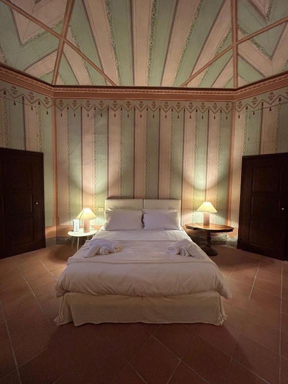 a bedroom with a large bed with two tables at Le Suite Di Faenza in Faenza