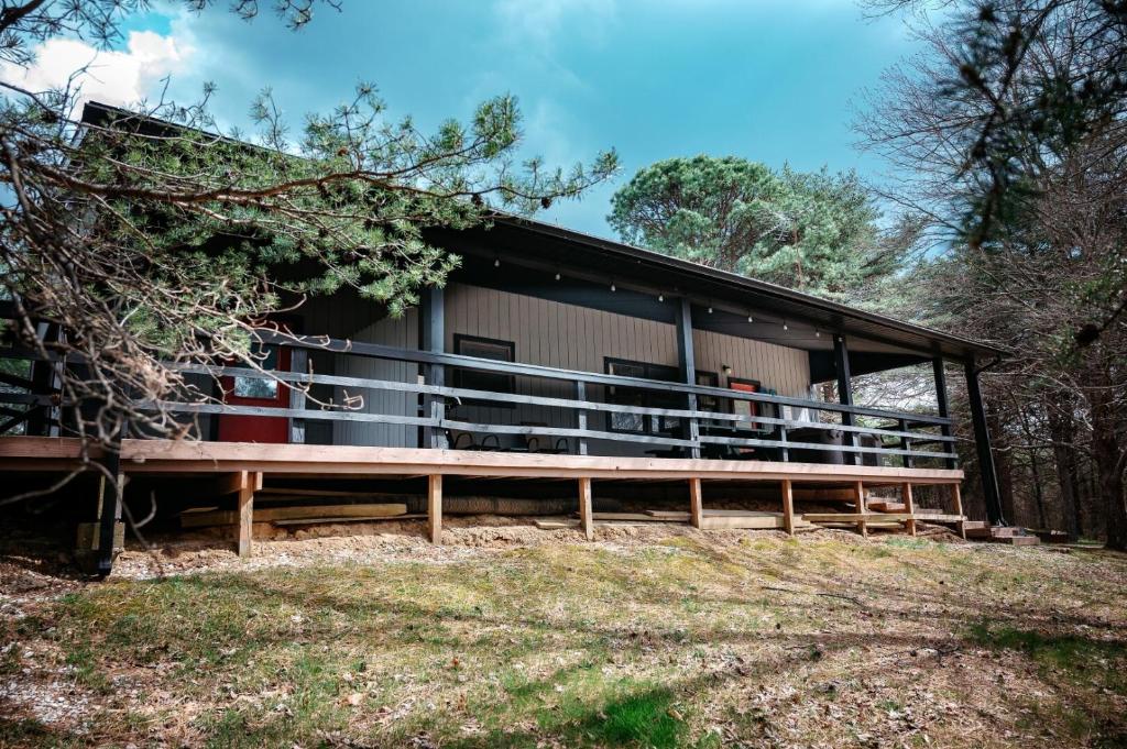 a building with a large deck in the woods at Blue Jay in South Bloomingville