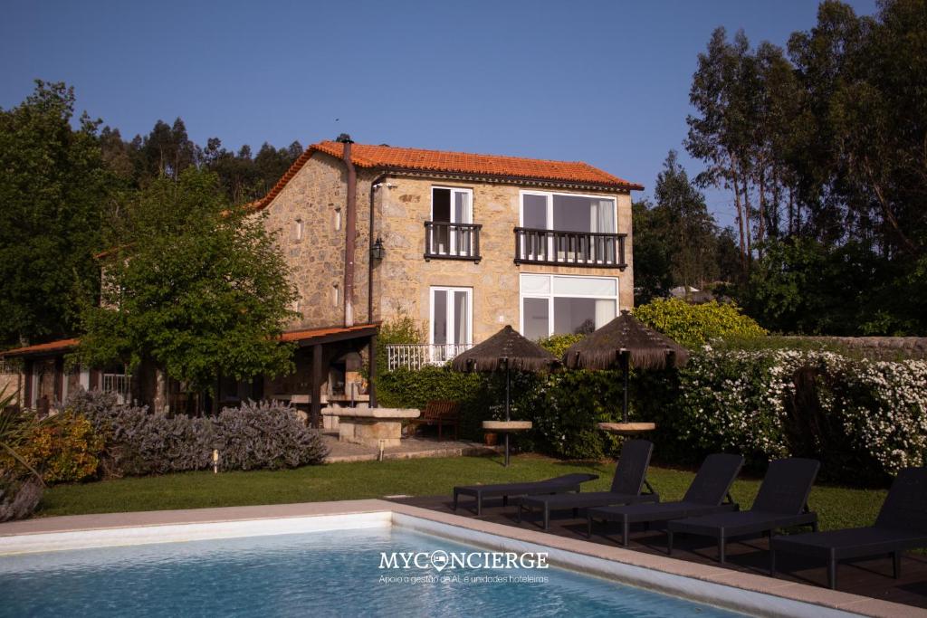 a house with a swimming pool in front of a house at Quinta Anna Horvath in Vale de Cambra