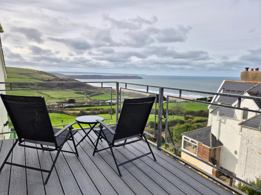 two chairs on a deck with a view of the ocean at 5 Seymour Villas in Woolacombe