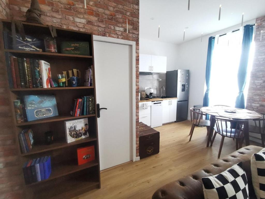 a living room with a door and a kitchen with a table at Appartement dans l'univers Harry Potter in Rosporden