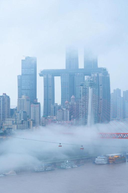 a foggy view of a city with buildings in the background at Wave Nest 汐宿 in Chongqing