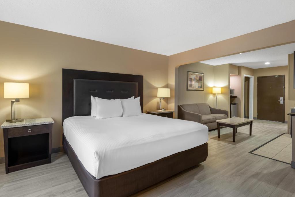 a hotel room with a bed and a chair at Best Western Lumberton in Lumberton