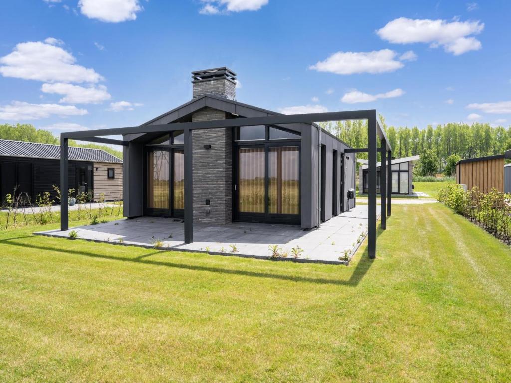a house with a black roof on a lawn at Bollen in Oud-Ade