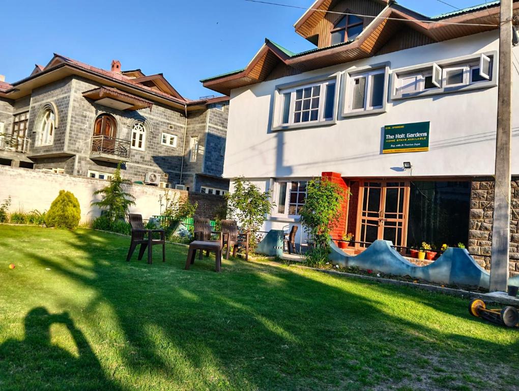 a house with a lawn in front of it at The Holt Gardens in Srinagar