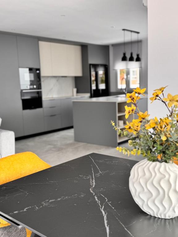 a kitchen with a table with a vase with flowers on it at Casa Benicasim in Benicàssim