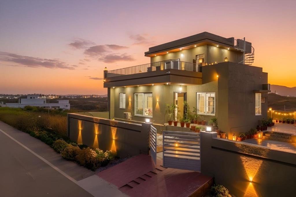 a house with lights on it at sunset at Ellara Homes in Udaipur