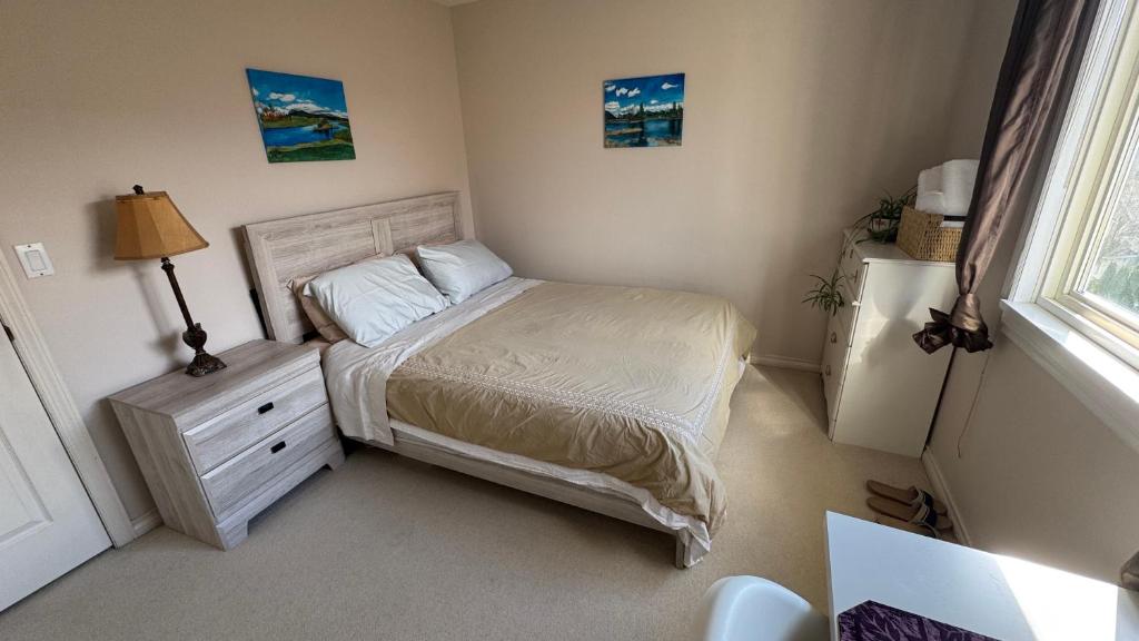 a bedroom with a bed and a dresser and a window at warm house2 in Coquitlam