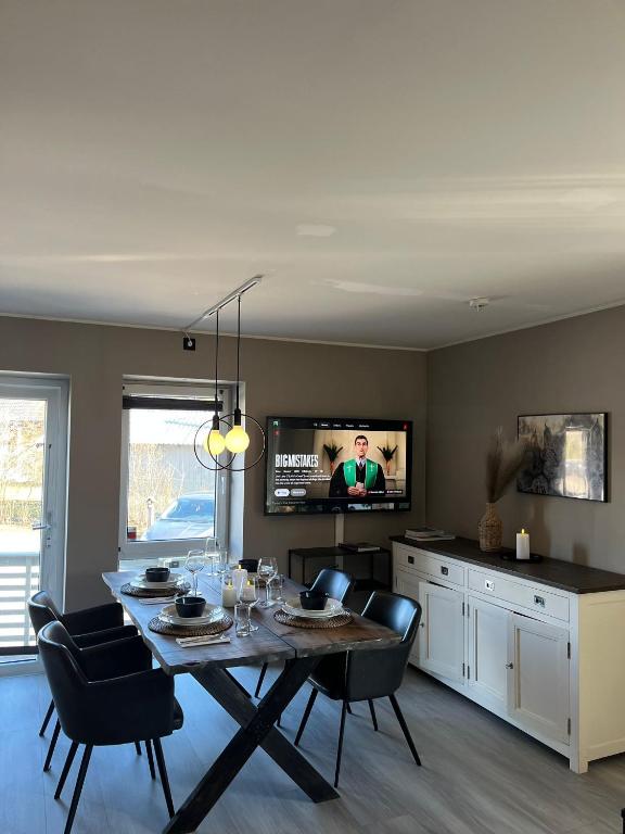 a dining room with a table and chairs and a tv at Modern & Central - Free Parking & Stylish Decor in Vossevangen