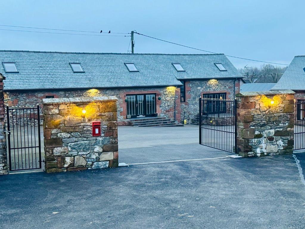 a stone building with a gate in front of it at The Steading in Dumfries