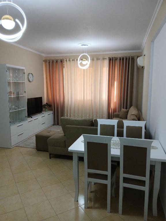 a living room with a couch and a table with chairs at Nik's Cozy Apartment in Berat