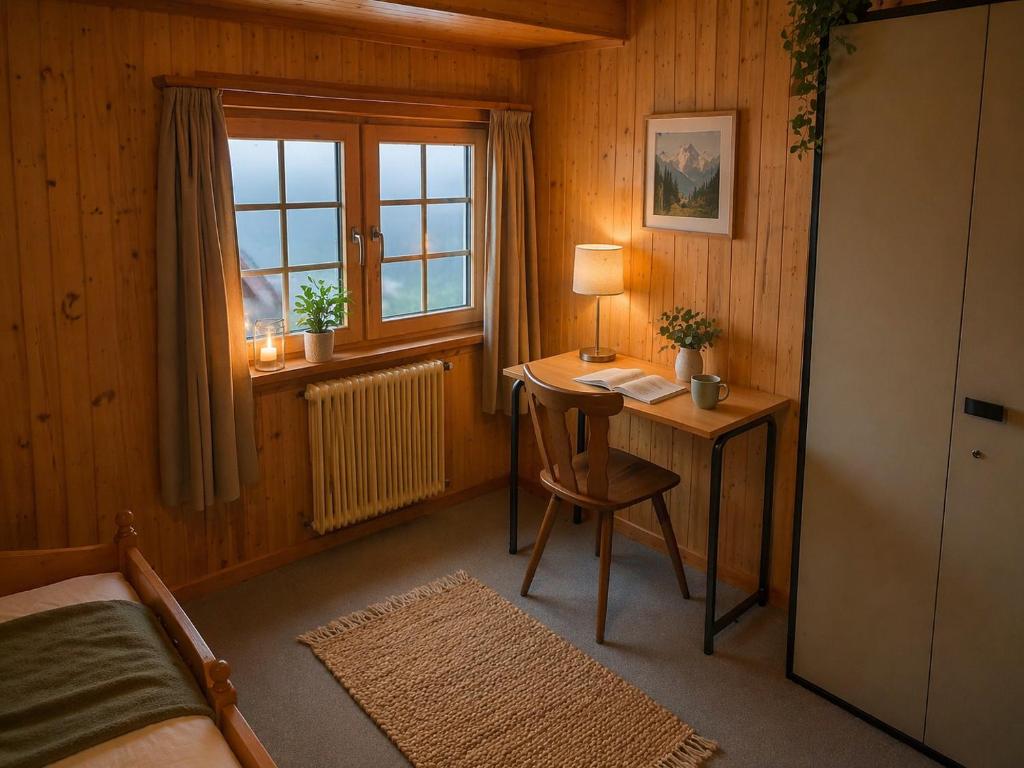a bedroom with a desk and a bed and a window at Ferienwohnungen Pez Regina in Lumbrein