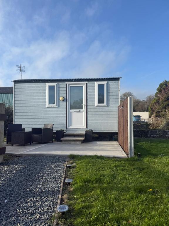 a tiny house with a patio and a fence at The Pod in Abererch