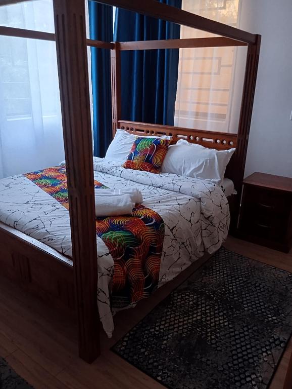 a bedroom with a bed with a wooden frame at Casa Marabella C3 in Diani Beach
