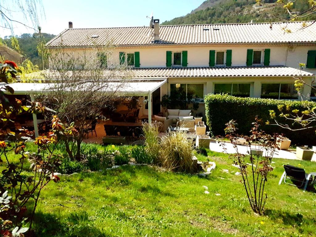 a house with a garden in front of it at Hôtel Restaurant Le Lachens in La Bastide