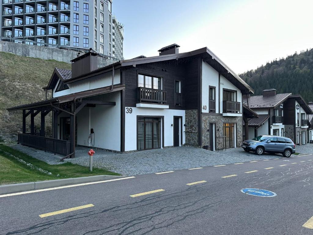 a car parked in front of a house on a street at Mountain Residence 4* in Bukovel
