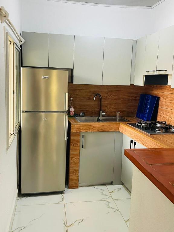 a kitchen with a stainless steel refrigerator and a sink at Roi immo 2 in Mahajanga