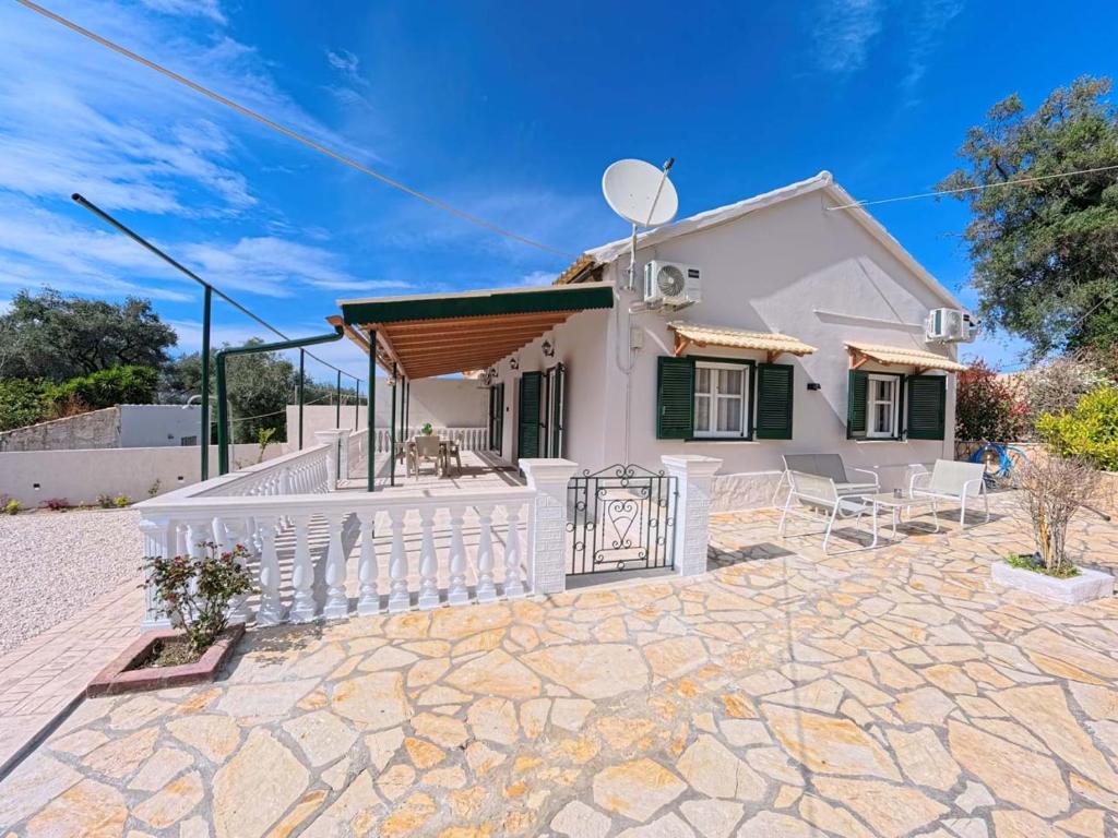 a white house with a porch and chairs at The Homey in Sidari