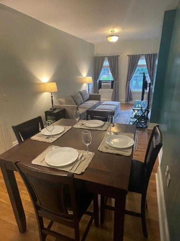 a dining room table with chairs and a living room at Uptown Geneva Rowhouse Flat in Geneva