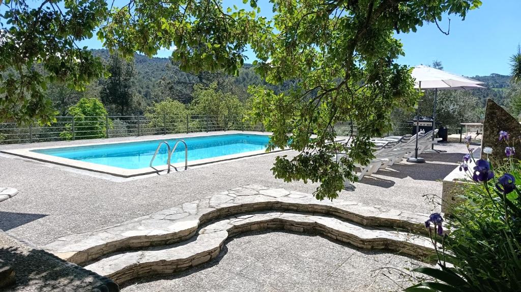 a swimming pool with a stone walkway around it at Bosquet de l'Auró in Argençola