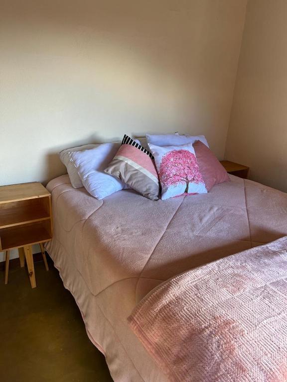 a bed with pillows on it in a room at Chalé da Janela in Lavras Novas