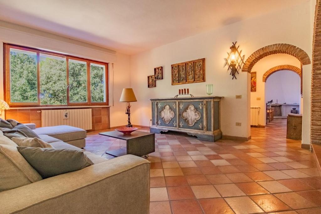 a living room with a couch and a fireplace at Villa la Paolina in Marciana
