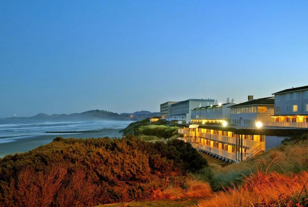 a row of buildings next to the ocean at night at Seagrass Oceanfront Inn in Newport