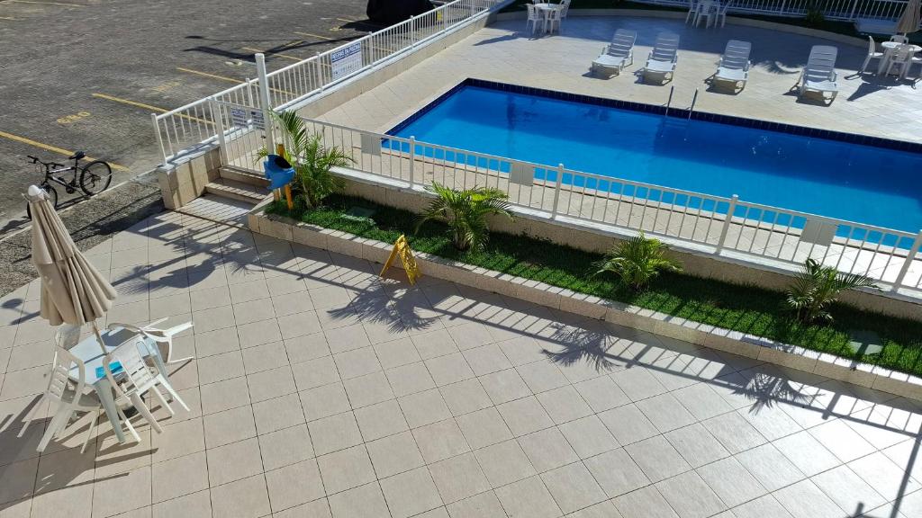 an overhead view of a swimming pool with chairs and an umbrella at Ilhéus Temporada in Ilhéus