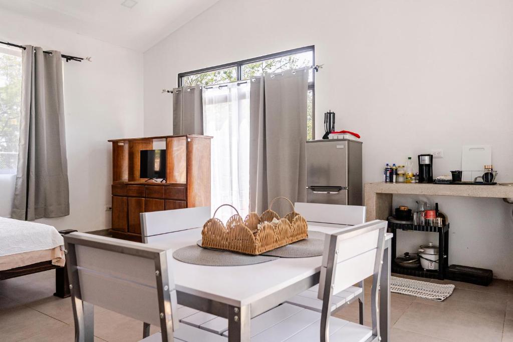 a dining room with a table and chairs and a kitchen at Casa Paula in Liberia