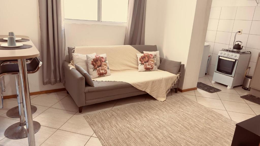 a living room with a couch and a stove at Apartamento perto do HCAA - com Garagem in Santa Maria