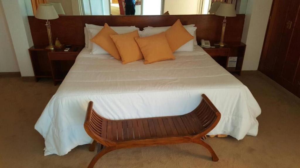 a bedroom with a large bed with orange pillows at Ohasis Hotel Jujuy & Spa in San Salvador de Jujuy