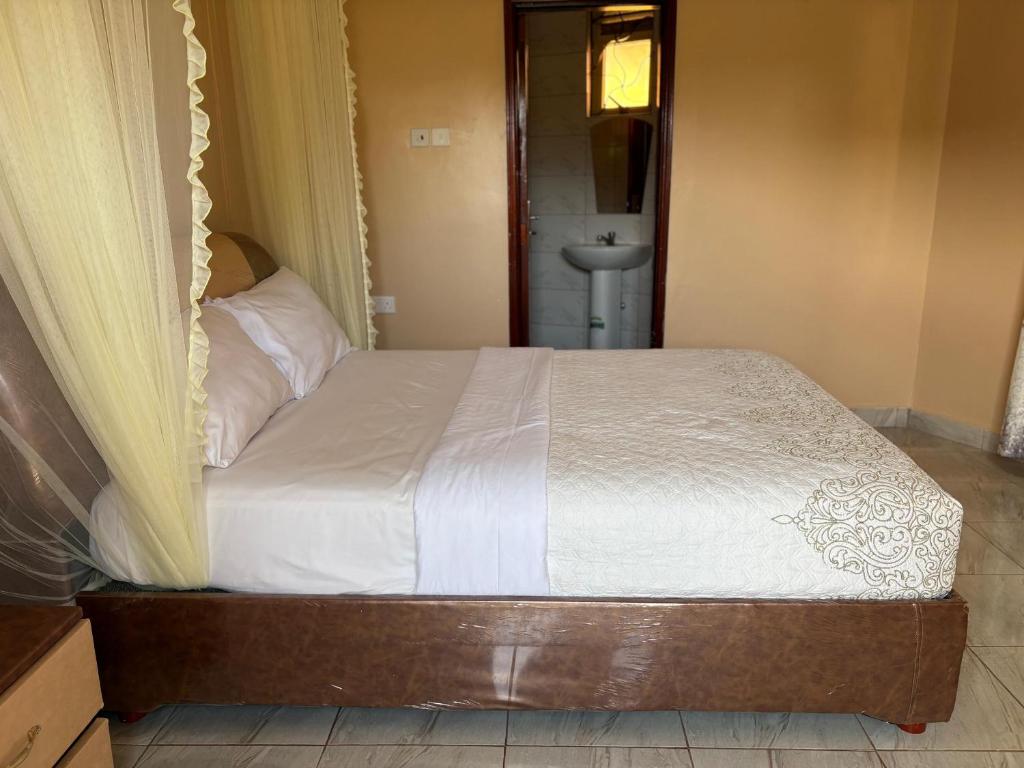 a bed in a room with a bed frame at Wilna Motel Garuga in Kagolomolo