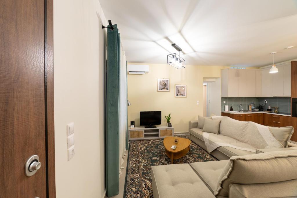 ein Wohnzimmer mit Sofa und Fernseher in der Unterkunft Kariatides in Sparta