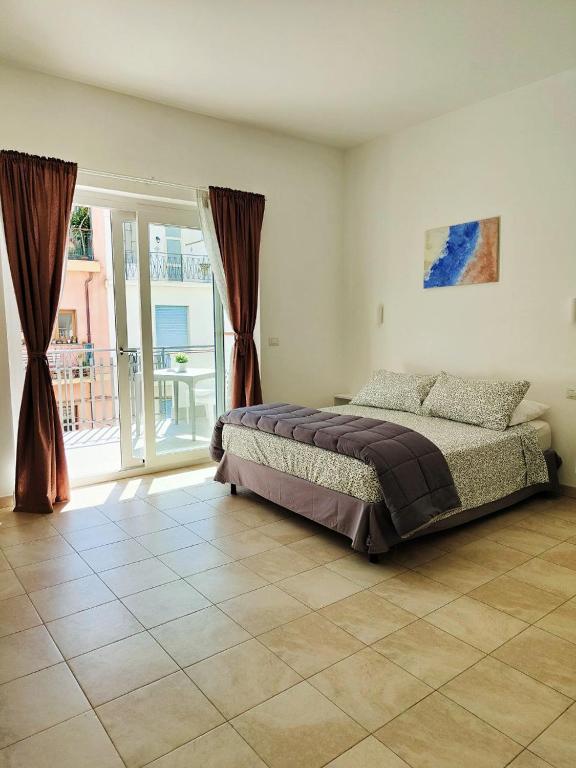 a bedroom with a bed and a large window at M&C Home in Letojanni