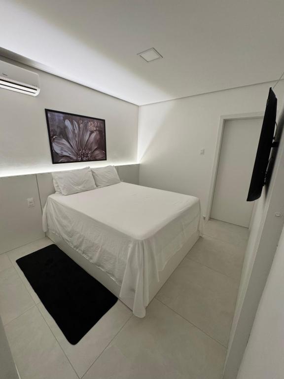 a small bedroom with a white bed in a room at Flat Bugayalê Lounge in Garanhuns