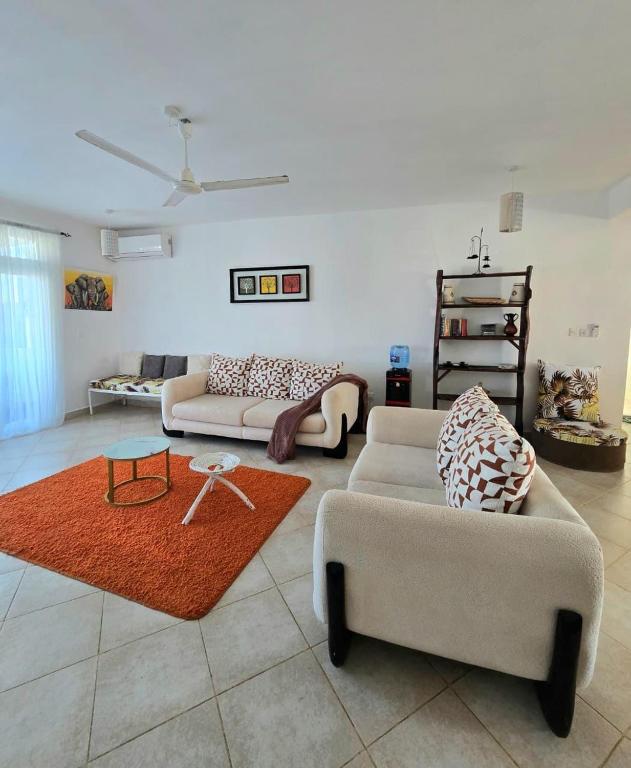 a living room with two couches and a rug at Malindi Getaway, Near Beach in Malindi