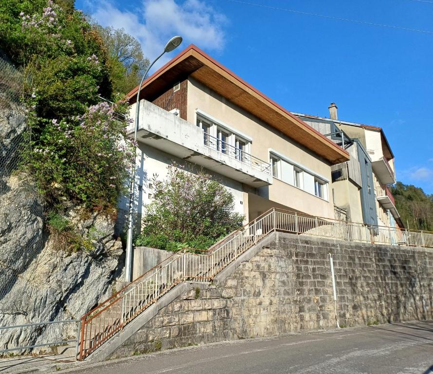 a house on the side of a hill with stairs at Gite La Cueille in Saint-Claude