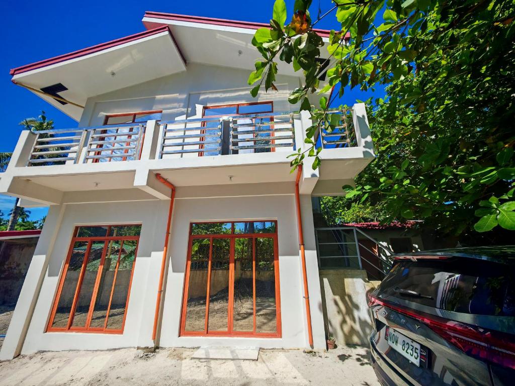 a house with a balcony and a car parked in front at Pacific View Point in Matnog