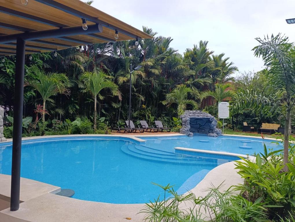 a swimming pool in a resort with palm trees at Villas Kiki in Puerto Viejo