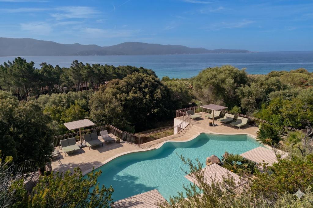 an aerial view of a swimming pool with the ocean in the background at Résidence La Plage in Propriano
