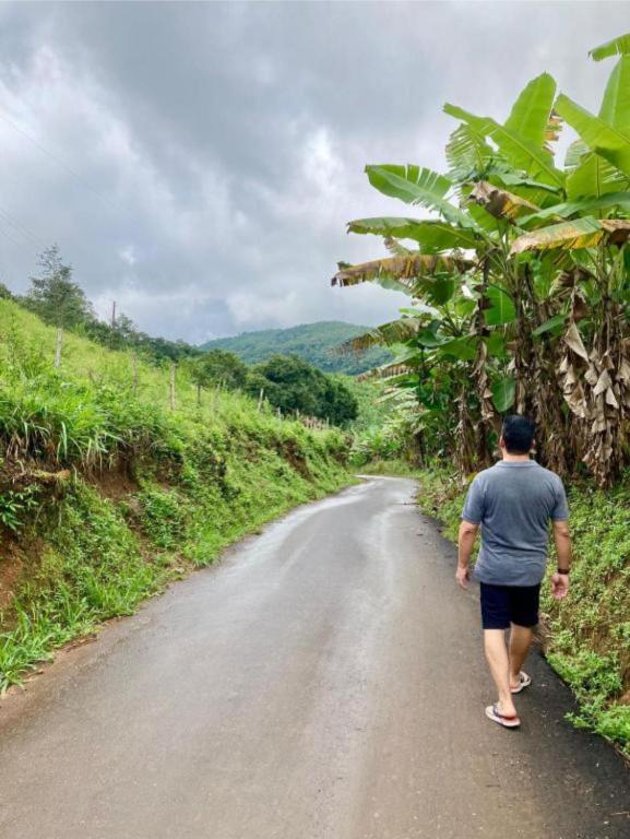 a man walking down a dirt road at Chalé Guaíras in Mulungu