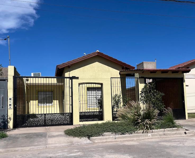 a house with a fence in front of it at Entre Montañas in Rivadavia