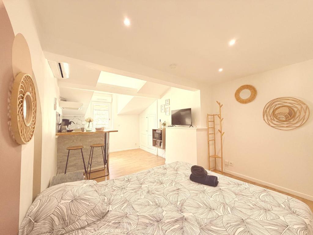 a bedroom with a bed and a kitchen at Les nids de Lagasse in Agen