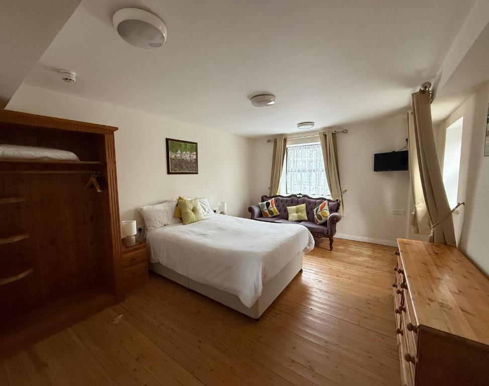 a bedroom with a bed and a couch in it at Kerry Ocean Lodge Room only in Glenbeigh