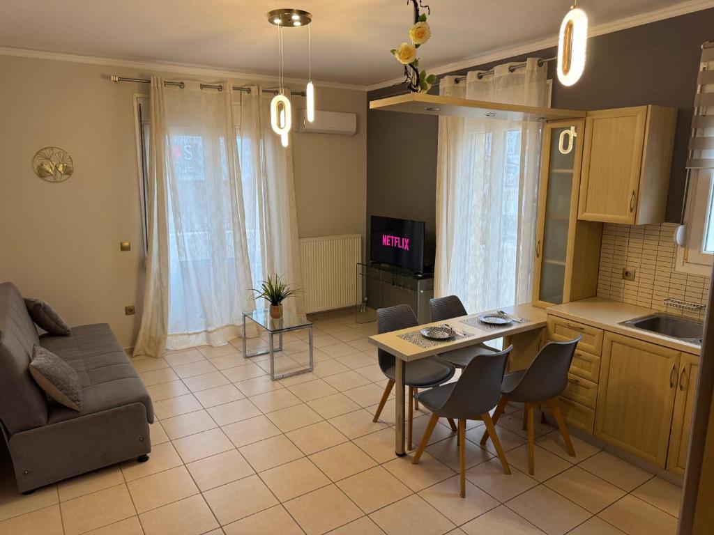 a kitchen and a living room with a table and chairs at K A P Home in Chios