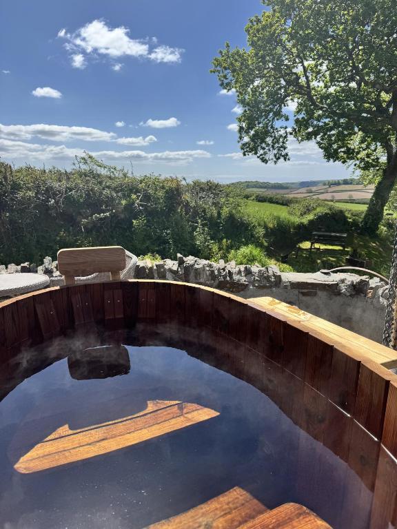 a pool of water with a wooden bridge at Nuthatch Cottage in Cardinham