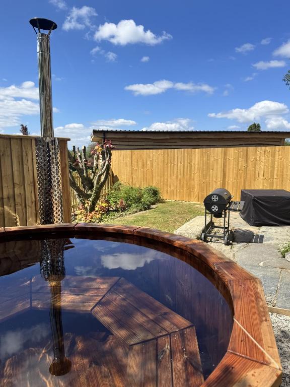 a pool in a backyard with a wooden table at Tawnawood in Cardinham