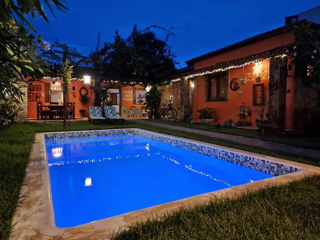 a swimming pool in the yard of a house at night at Casa Dos Patos in Flecheiras